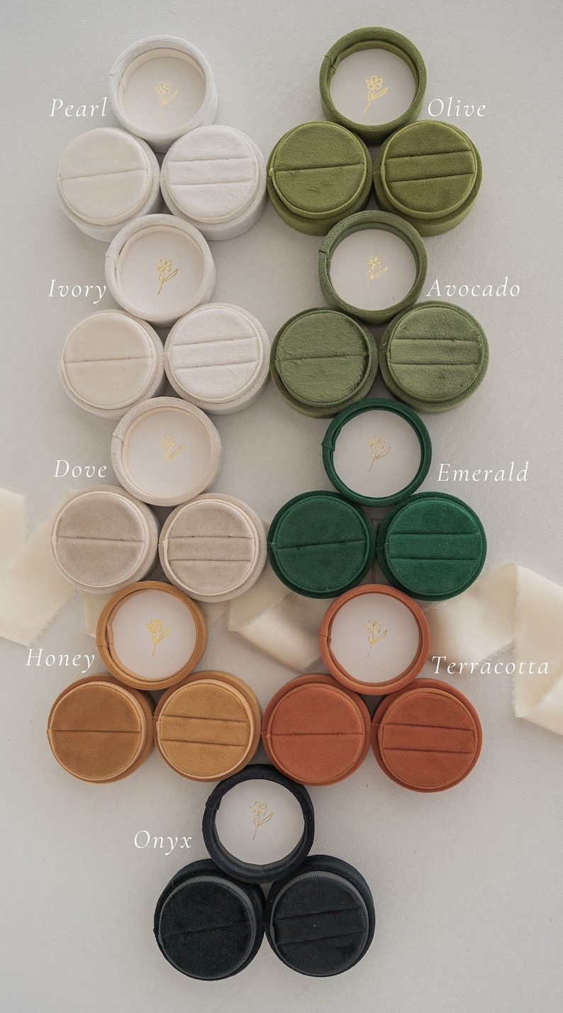 May include: Assortment of 12 velvet ring boxes in various colors, including pearl, ivory, dove, honey, onyx, olive, avocado, emerald, terracotta. Each box features a small floral design.