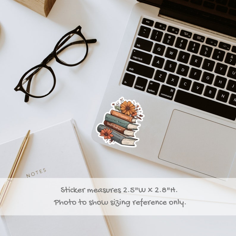 May include: A sticker featuring a stack of five books with floral accents. The books are illustrated with a vintage aesthetic and have titles like "World's Greatest Stories" and "The Adventures of Sherlock Holmes". The sticker measures 2.5 inches wide by 2.8 inches tall.