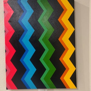 Może przedstawiać: Abstrakcyjny obraz z chevronem w odcieniach czerwieni, błękitu, zieleni, pomarańczy i ż&oacute;łci na czarnym tle.