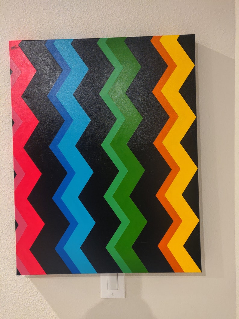 Może przedstawiać: Abstrakcyjny obraz z chevronem w odcieniach czerwieni, błękitu, zieleni, pomarańczy i ż&oacute;łci na czarnym tle.