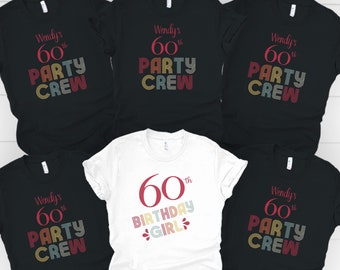 May include: A collection of five short-sleeved t-shirts. Four black shirts feature the text Wendy's 60th PARTY CREW in multi-colored retro lettering. One white shirt features the text 60th BIRTHDAY GIRL in red and multi-colored retro lettering.
