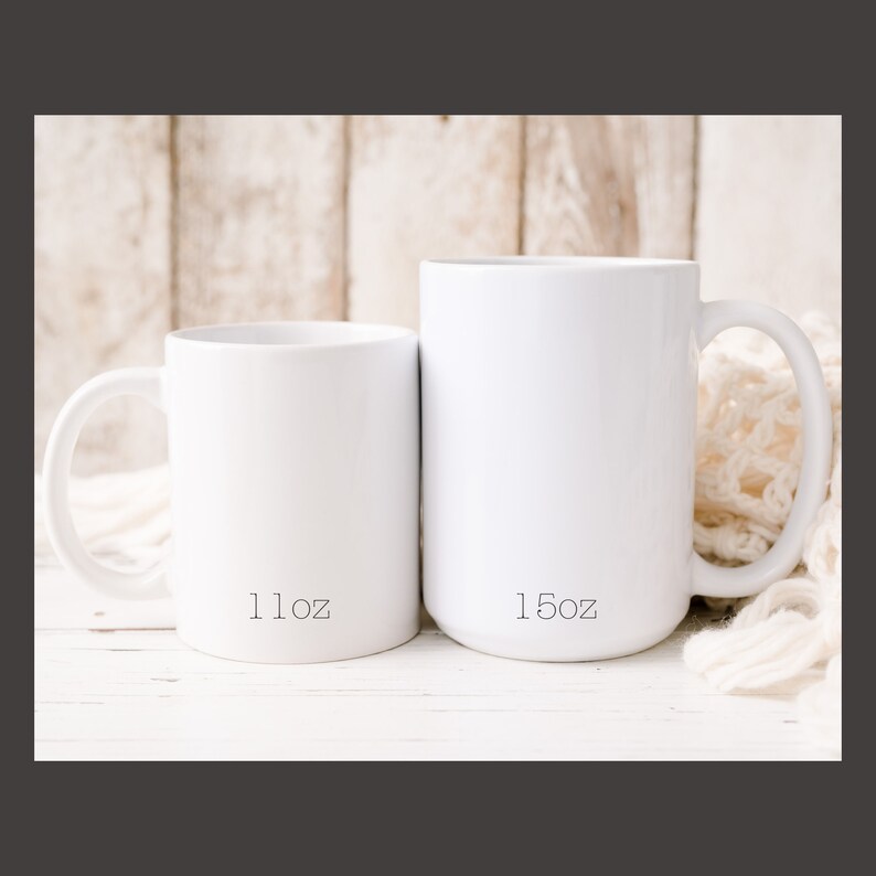 May include: Two white ceramic mugs, one 11 oz and the other 15 oz, sitting on a white wooden surface.