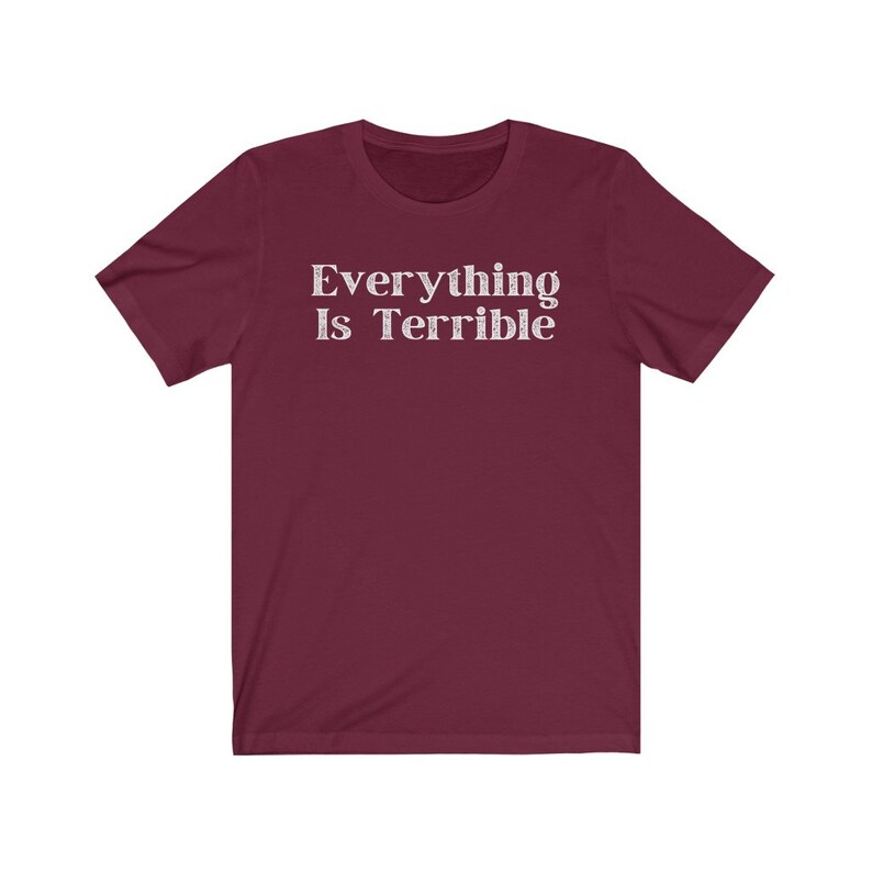May include: A maroon short-sleeved t-shirt with the text "Everything Is Terrible" printed in white.