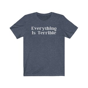 May include: A dark blue t-shirt with the text "Everything Is Terrible" printed in white.