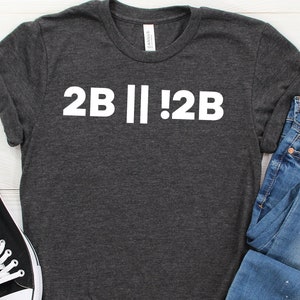 May include: A dark heather grey t-shirt with white text that reads "2B || !2B".