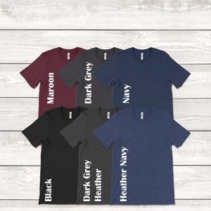 May include: Six t-shirts in different colors, including maroon, dark grey, navy, black, heather grey, and heather navy. Each shirt has a white text label on the side indicating the color.