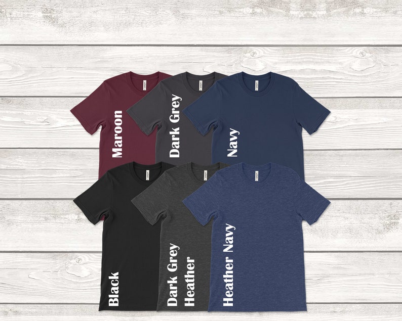 May include: Six t-shirts in different colors, including maroon, dark grey, navy, black, heather grey, and heather navy. Each shirt has a white text label on the side indicating the color.