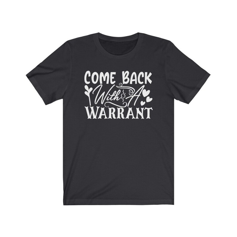 Peut inclure: T-shirt &agrave; manches courtes noire avec un texte blanc qui dit "Come Back With A Warrant" et un petit graphique en forme de c&oelig;ur.