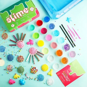 May include: A DIY slime kit with various colorful slime ingredients, including glitter, beads, and small plastic molds. The kit includes a green and red box with the words "DIY Slime Kit" and an inflatable blue pool.