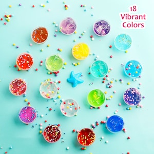 May include: An overhead shot of 18 vibrant colors of slime in small, clear containers. The slime colors include red, orange, yellow, green, blue, and purple, with colorful sprinkles and a blue starfish scattered around. Text reads "18 Vibrant Colors."