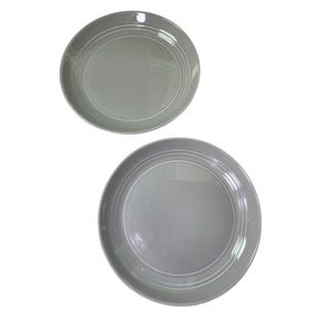 May include: Two gray ceramic plates with a white concentric circle design. The plates are round and have a slightly raised rim. The plates are set against a white background.