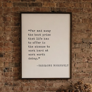 May include: A rectangular framed wall art piece featuring the black text: Far and away the best prize that life has to offer is the chance to work hard at work worth doing. -THEODORE ROOSEVELT. The print is set against a white background.