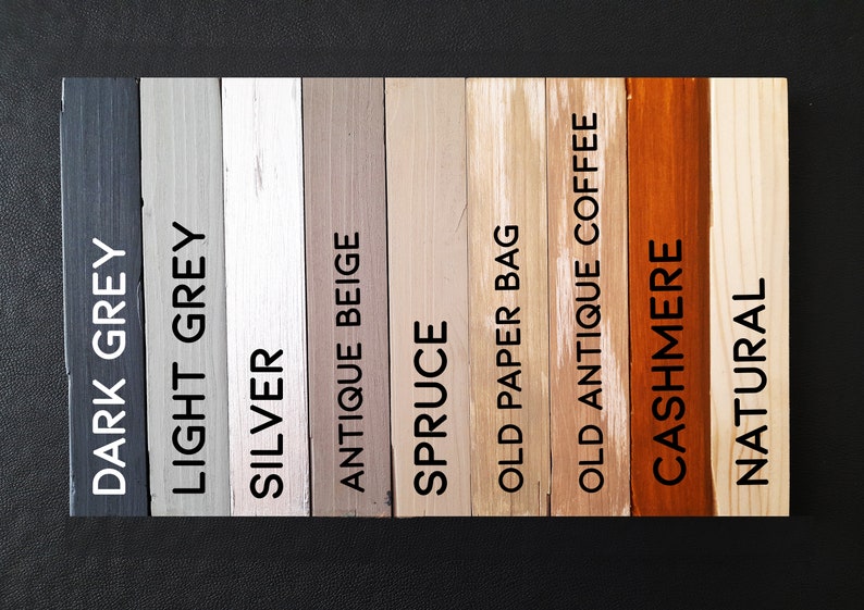 May include: A collection of wooden color swatches labeled with paint names. Colors range from dark grey to natural, including light grey, silver, antique beige, spruce, old paper bag, old antique coffee, and cashmere.