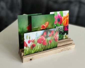 Könnte beinhalten: Holz-Kartenhalter mit vier Fächern, der Karten mit Blumenbildern zeigt. Die Karten zeigen rote Mohnblumen, rosa und orangefarbene Blumen und grünes Laub. Der Text auf einer Karte lautet "Flowers Make You Smile."