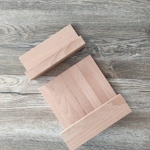 May include: Two wooden shelves, one stacked on top of the other, with a natural wood finish. The shelves are made of solid wood and have a simple, rectangular shape.