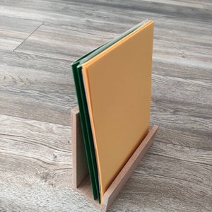 May include: A wooden magazine holder with a stack of papers in green and orange.