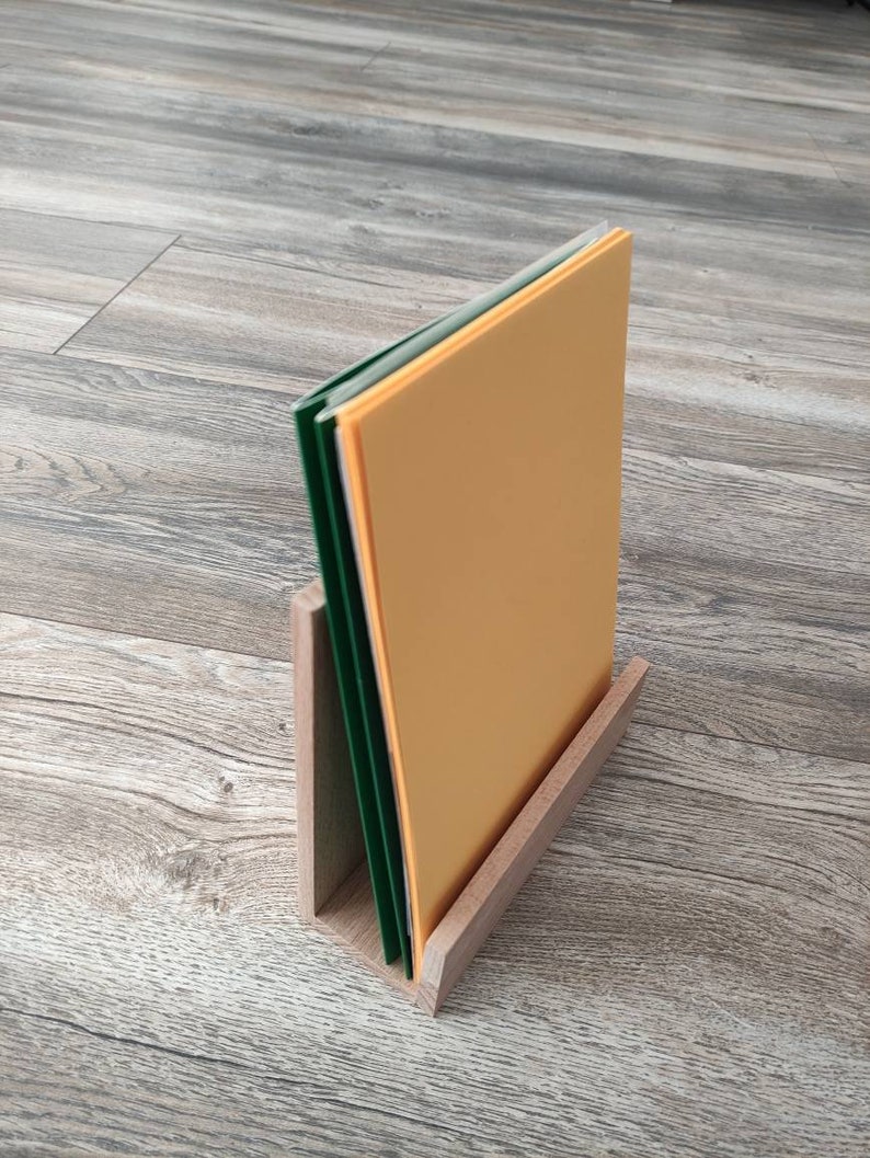 May include: A wooden magazine holder with a stack of papers in green and orange.