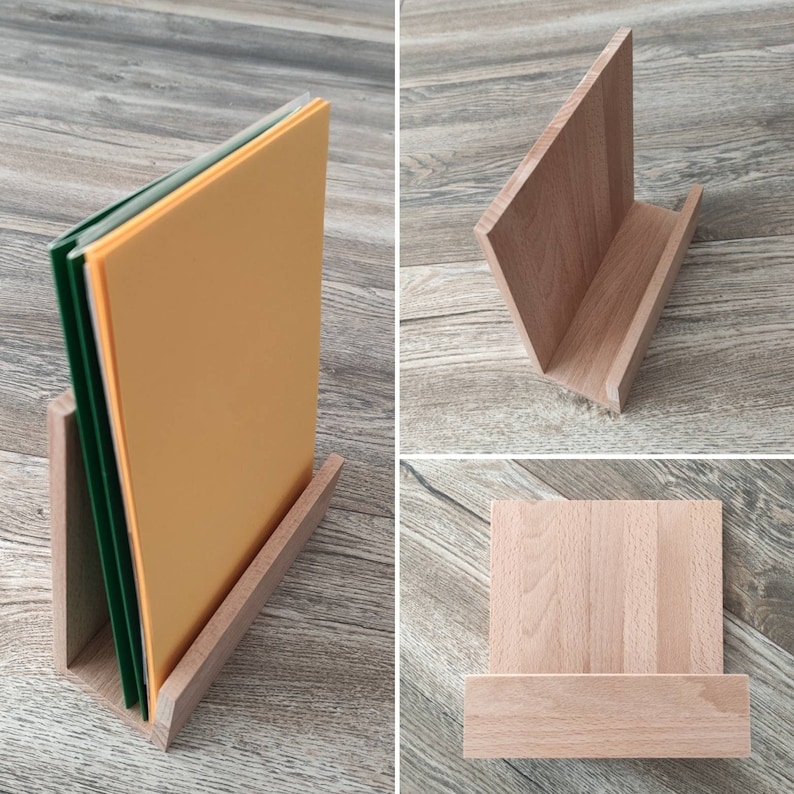 May include: A wooden stand with a slanted back and a flat base. The stand is designed to hold papers or books upright. The stand is made of light brown wood and has a natural finish.