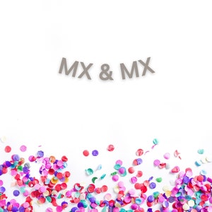 May include: A white background with the text "MX & MX" in gray letters. The bottom of the image is covered in colorful confetti.
