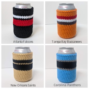May include: Four crocheted can coolers in team colors. The coolers are black and red, orange and brown, tan and black, and blue and gray. Each cooler has the team name printed below it: Atlanta Falcons, Tampa Bay Buccaneers, New Orleans Saints, and Carolina Panthers.