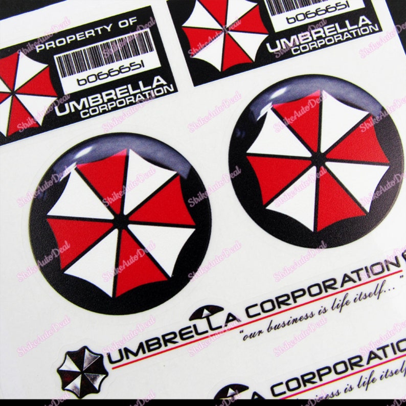 May include: A set of five stickers featuring the Umbrella Corporation logo. The logo is a black and white umbrella with a red center. The stickers are printed on a white background. The text "Umbrella Corporation" and "our business is life itself..." is printed on the stickers.