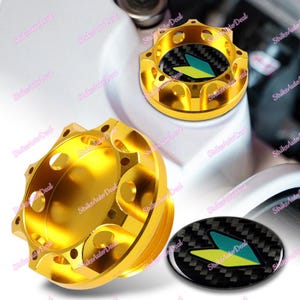 May include: Gold metal oil filler cap with a black and green carbon fiber sticker featuring a stylized arrow design.
