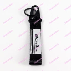May include: Black key chain with a silver hook and a black strap with white stripes and the text "藤原とうふ店(自家用)" in Japanese.