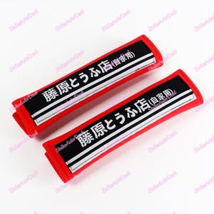 Puede incluir: Dos reposacabezas de asiento de coche rojos con texto en blanco y negro que dice "藤原とうふ店 (自家用)" que se traduce como "藤原 Tofu Shop (Uso Privado)".