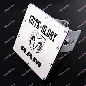 May include: Silver hitch cover with a black Ram logo and the text "GUTS-GLORY RAM".