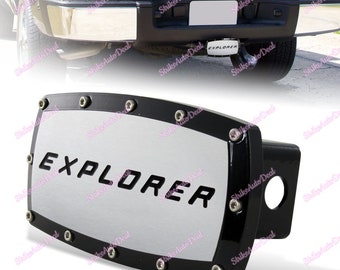 May include: Black and silver hitch cover with the word "EXPLORER" in black lettering. The cover has a silver background and a black border with silver screws.