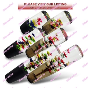 May include: Several clear glass car shift knobs with colorful flower arrangements inside. The knobs have black bases and the text "PLEASE VISIT OUR LISTING FOR MORE COLORS" is visible at the top.