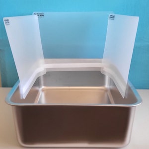 Litter shields attached to a stainless steel cat litter box.