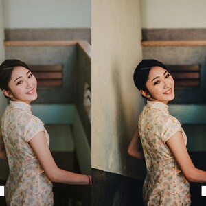 May include: A woman in a white and yellow floral dress smiles and looks over her shoulder. She is standing on a staircase with a white wall behind her.