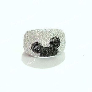 K&ouml;nnte beinhalten: Ein silberner Ring mit einem schwarzen Diamanten-Mickey-Mouse-Design. Der Ring ist mit kleinen wei&szlig;en Diamanten besetzt.