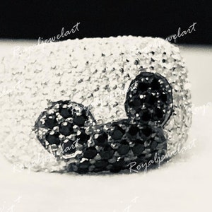 K&ouml;nnte beinhalten: Ein silberner Ring mit einem schwarzen und wei&szlig;en Mickey Mouse Design. Der Ring ist mit kleinen, funkelnden Steinen besetzt.