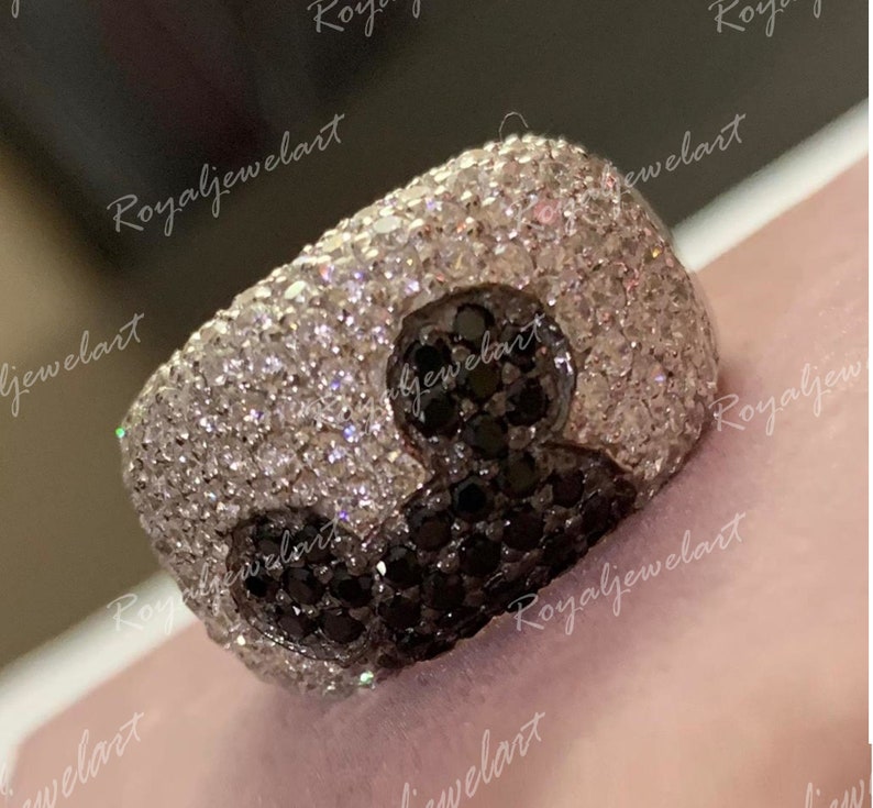 K&ouml;nnte beinhalten: Ein silberner Ring mit einem Yin-Yang-Design. Das Yin besteht aus schwarzen Steinen und das Yang aus wei&szlig;en Steinen.