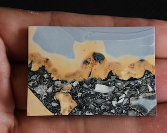 Puede incluir: Una losa pulida de jaspe azul, amarillo y negro con un patrón único. La piedra tiene una superficie lisa y pulida y es un hermoso ejemplo de este tipo de piedra preciosa.