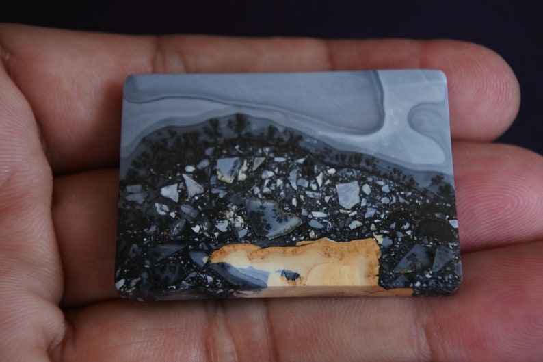 May include: A rectangular slab of polished agate with a swirling pattern of gray, black, and brown. The stone has a unique, marbled appearance.