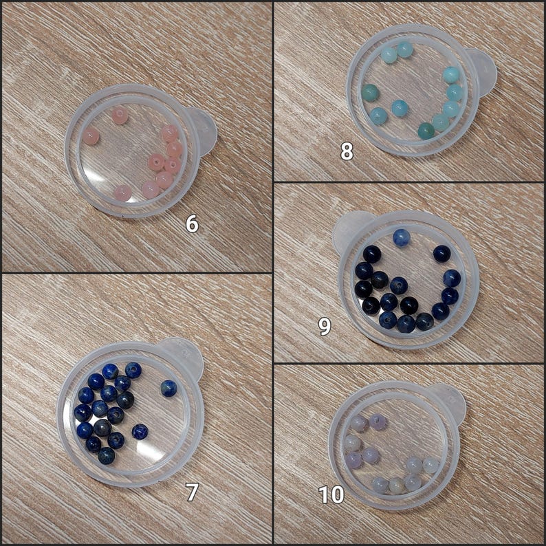 Puede incluir: Cinco peque&ntilde;os recipientes de pl&aacute;stico transparente con tapas, cada uno con cuentas de piedras preciosas de diferentes colores. Las cuentas son rosas, celeste, azul oscuro y lavanda. Los recipientes est&aacute;n etiquetados con los n&uacute;meros 6, 7, 8, 9 y 10.