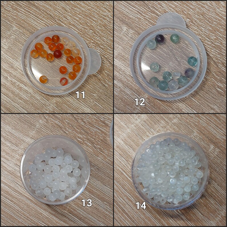 Puede incluir: Cuatro peque&ntilde;os recipientes de pl&aacute;stico transparente con tapas, cada uno con una colecci&oacute;n de cuentas. Las cuentas son de varios colores, incluyendo naranja, verde, morado y blanco. Los recipientes est&aacute;n etiquetados con los n&uacute;meros 11, 12, 13 y 14.