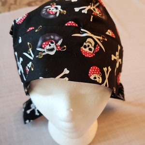 May include: Black fabric skull cap with a pirate skull and crossbones pattern. The cap has a tie at the back.