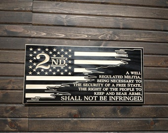 May include: A wooden sign with a black and white American flag design. The sign features the text "2nd" and the Second Amendment of the United States Constitution.