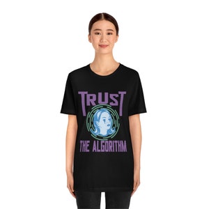 May include: Black t-shirt with a purple and blue graphic that says "TRUST THE ALGORITHM". The graphic features a stylized image of a woman's face.