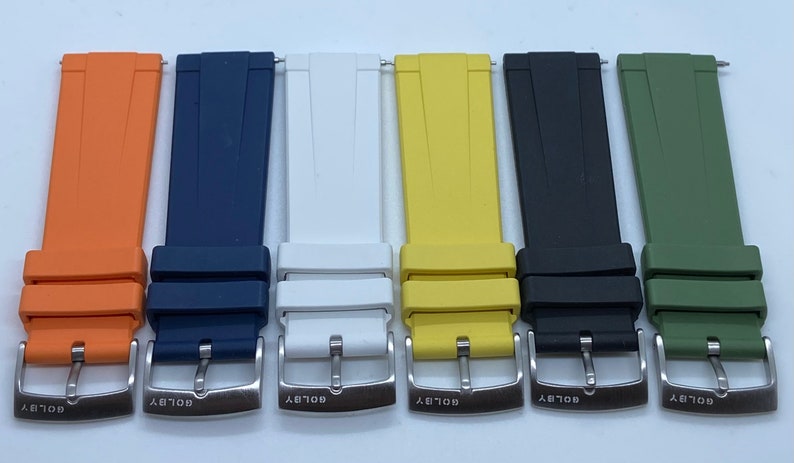 May include: Six different coloured watch straps with silver buckles. The straps are orange, blue, white, yellow, black, and green.