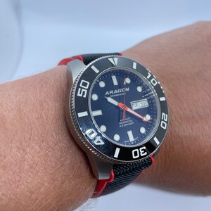 Puede incluir: Un reloj de pulsera negro y rojo con una esfera negra y marcas blancas. El reloj tiene un bisel giratorio con n&uacute;meros blancos y una ventana de fecha que dice "TUE 30". La esfera del reloj tambi&eacute;n tiene el texto "ARAGON DIVEMASTER" y "AUTOMATIC PROFESSIONAL WR 200M/660FT".