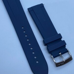 May include: A dark blue silicone watch strap with a silver buckle that says "GOLDSKY".