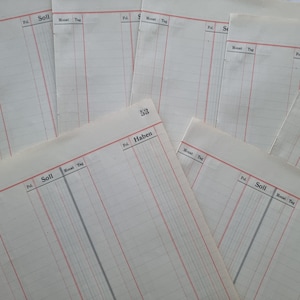 Könnte beinhalten: Eine Sammlung von Vintage-Registerblättern. Die Seiten sind cremefarben mit roten und schwarzen gedruckten Linien und Text. Der Text enthält "Soll", "Haben", "Monat" und "Tag". Die Nummer "53" ist auf einem Blatt gedruckt.