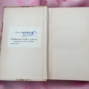 May include: An open book with aged, off-white pages. The left page features a label from the "First Ward Branch" of the Binghamton Public Library, marked "DISCARD". The book is presented by Mrs. Stiffey.