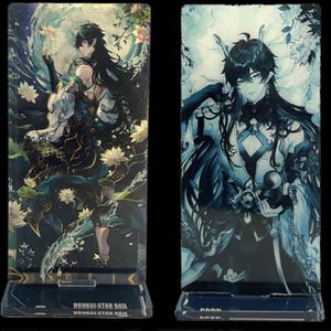 May include: Two acrylic stands featuring anime characters from the video game Honkai Star Rail. The stands are clear with a black base and feature a character with black hair and blue eyes. The character on the left is wearing a blue and gold outfit with a white sash. The character on the right is wearing a white and blue outfit with a black sash. Both characters have a white background with a blue and white swirl pattern.