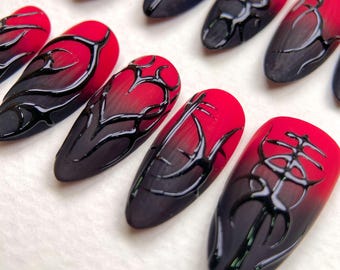 Unghie finte opache rosse e nere: nail art con tatuaggio tribale